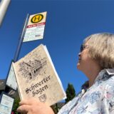 Ulrike Berkenhoff hält an der Bushaltestelle Auf der Gunst eine Sammlung der Schwerter Sagen hoch.
