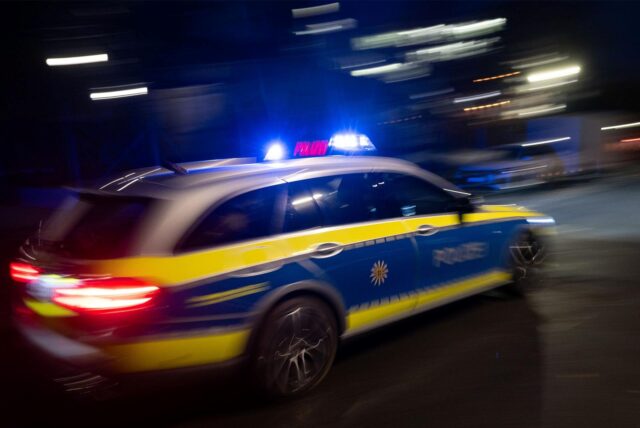Ein Polizeiauto fährt mit Blaulicht vorbei.