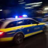Ein Polizeiauto fährt mit Blaulicht vorbei.