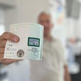 Ein Mann hält einen Kraftfahrzeugschein mit einem Siegel des Kreises Unna.