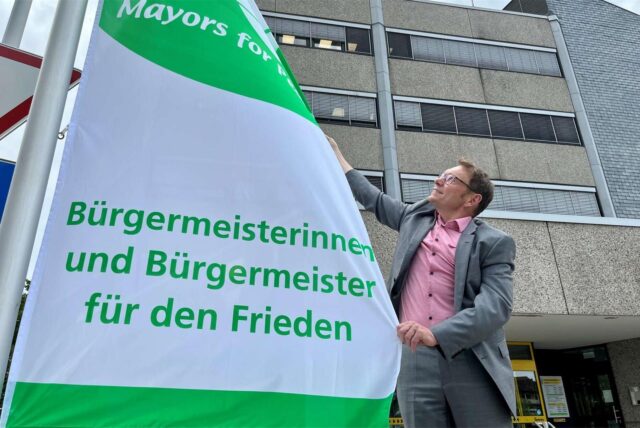 Bürgermeister Lothar Christ mit der „Mayors for Peace”-Flagge vor dem Stadthaus in Werne.