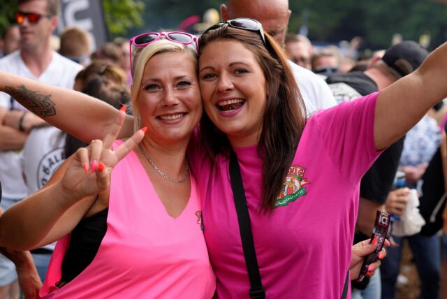 Zwei Frauen mit pinken Shirts lachen in die Kamera
