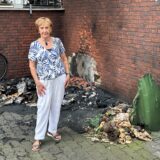 Hausbewohnerin Edith Brix vor den Resten der verbrannten Mülltonnen an einem Wohn- und Geschäftshaus an der Kämerstraßé