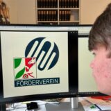 Ein Schüler betrachtet das Logo des Fördervereins der Werteunion in NRW.