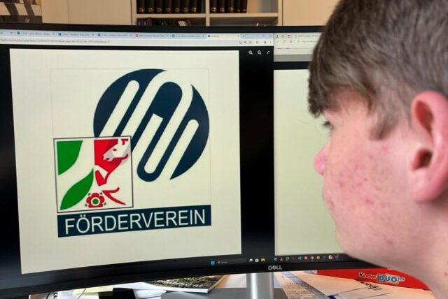 Ein Schüler betrachtet das Logo des Fördervereins der Werteunion in NRW.