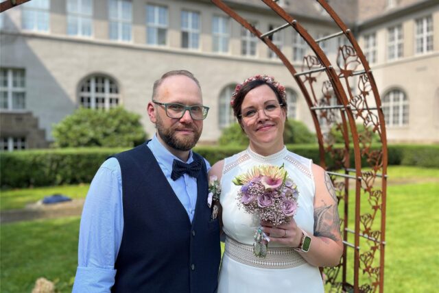 Danny und Marinila stehen frisch getraut vor dem Rathaus in Schwerte.