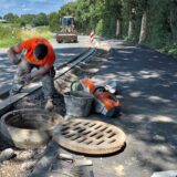 An der Türkenstraße in Unna arbeiten zwei Bauarbeiter. Im Hintergrund steht ein Radlader