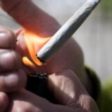 Bildmontage aus einem Ordnungsamtsmitarbeiter und einem Joint, der gerade angezündet wird.