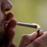 Ein Mann zündet sich einen Joint an