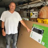 Joachim Michels steht in seiner Garage und zeigt auf das Stecker-Solar-Gerät, was er sich jetzt selbst angescgafft hat.