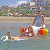 Zwei Frauen im Meer. Ein Vorbildstrand auf Teneriffa: Mit einem speziellen Rollstuhl können auch Behinderte ins Wasser.