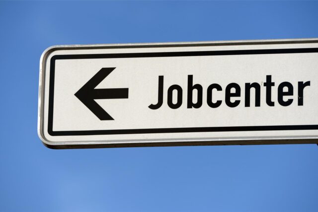Ein Hinweisschild zu einem Jobcenter.