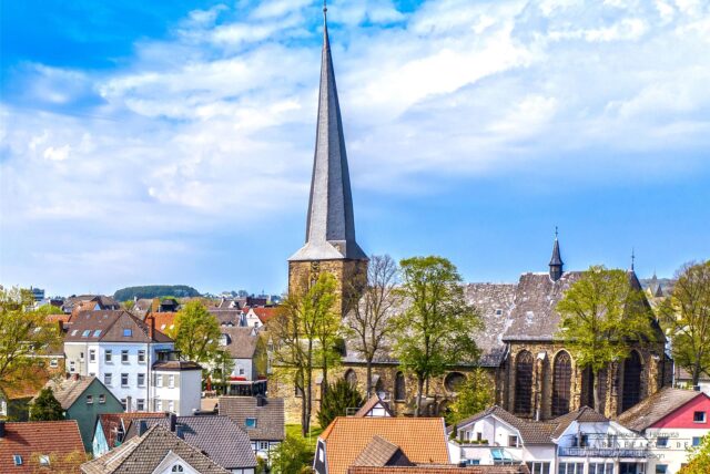 Die St. Viktor-Kirche und Schwerte vor blauem Himmel.