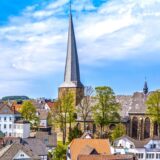 Die St. Viktor-Kirche und Schwerte vor blauem Himmel.
