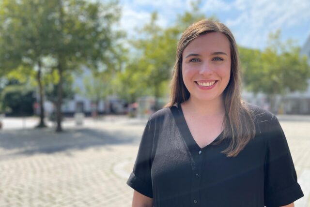 Melissa Meyer steht auf dem Alten Markt in Kamen und lacht in die Kamera. Porträtaufnahme.
