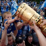 Ein junger Fan fasst am Sonntag (22.05.2011) in Gelsenkirchen während eines Autokorsos an den Pokal. Schalke ist Deutscher Pokalsieger 2010/2011. Foto: Bernd Thissen dpa/lnw ++ +++ dpa-Bildfunk +++