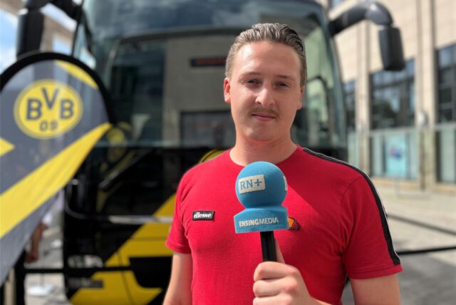 Tim Hübbertz hält ein Mikrofon auf dem Hansaplatz Dortmund in der Hand.