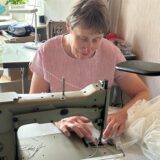 Hildegard Schmidtke sitzt an der Nähmaschine.