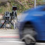 Ein Auto fährt an einem Blitzer vorbei.