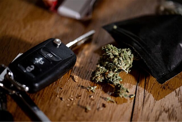 Cannabisblüten liegen auf einem Tisch neben einem Autoschlüssel.