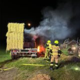 Feuerwehrleute im Einsatz: Neun Tonnen Stroh sind auf dem Anhänger geladen.