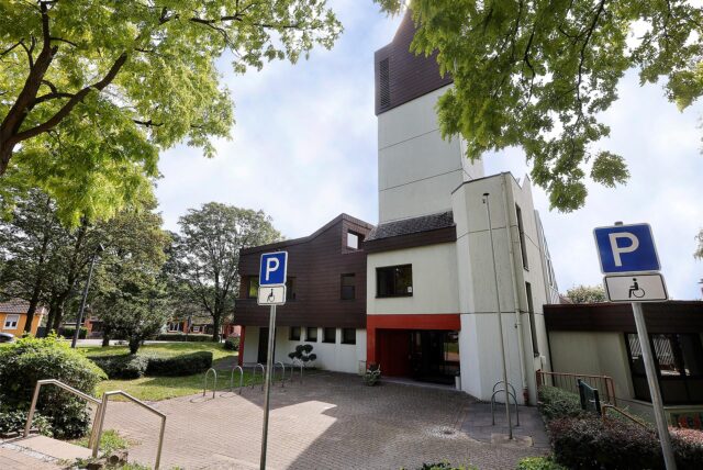 Zu sehen sind zwei ausgewiesene Behindertenparkplätze vor der Friedenskirche.