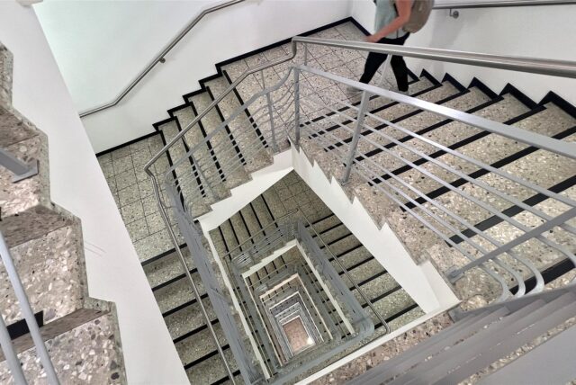 Eine Person geht im Treppenhaus des Kreishauses in Unna die Stufen herunter.