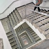 Eine Person geht im Treppenhaus des Kreishauses in Unna die Stufen herunter.