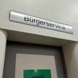 Ein Schild mit der Aufschrift „Bürgerservice“ hängt über einer Tür.