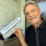 Paul-Gerhard Suchhardt aus Schwerte an seinem Briefkasten. Er zieht eine Stadtwerke-Werbung raus.