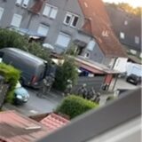 Polizisten vor einem Haus.