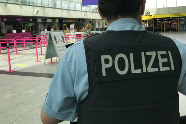 Ein Polizist steht in der Abflughalle des Flughafens Dortmund.