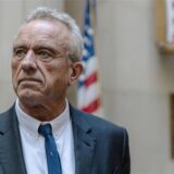 Portrait von Robert F. Kennedy Jr. mit der amerikanischen Flagge im Hintergrund.