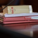 Das Strafgesetzbuch und Akten liegen auf einem Tisch.
