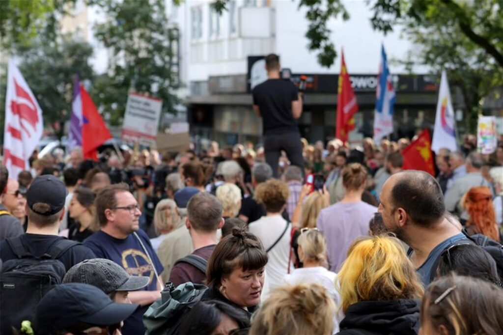 Teilnehmer einer Demonstration, die von linken Organisationen initiiert wurde, stehen in der Solinger Innenstadt.