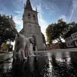 Ein Hund spielt auf dem Kirchplatz in Unna an einer der Fontänen des Boden-Wasserspiels