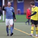 Janis Leenders (l.) im Dress vom Werner SC II gibt auf dem Platz Anweisungen. Ein Spieler vom SC Capelle läuft vorbei.