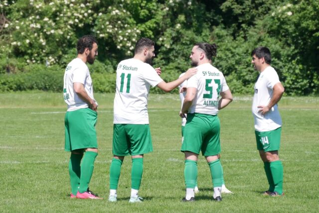 Vier Spieler vom SV Stockum beraten sich. Darunter der gesperrte Ali Altintas.