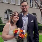 Alexandra und Sven stehen frisch verheiratet vor dem Schwerter Rathaus.