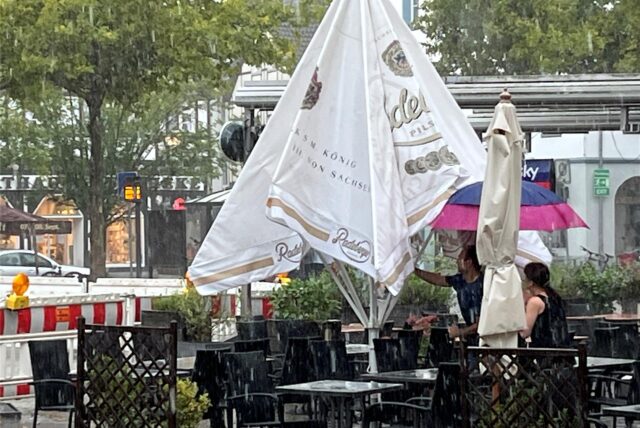 Kamener Wirte klappen bei Starkregen und Sturmböen eilig ihre Sonnenschirme zusammen.