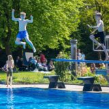 Jungen springen im Freibad Dellwig vom Sprungturm ins Becken