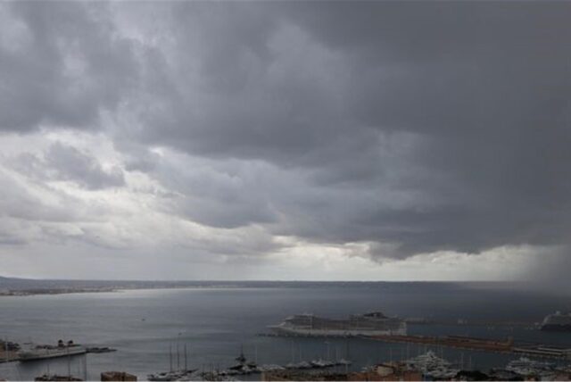 Dunkle Regenwolken hängen über der Bucht und dem Hafen von Palma de Mallorca.