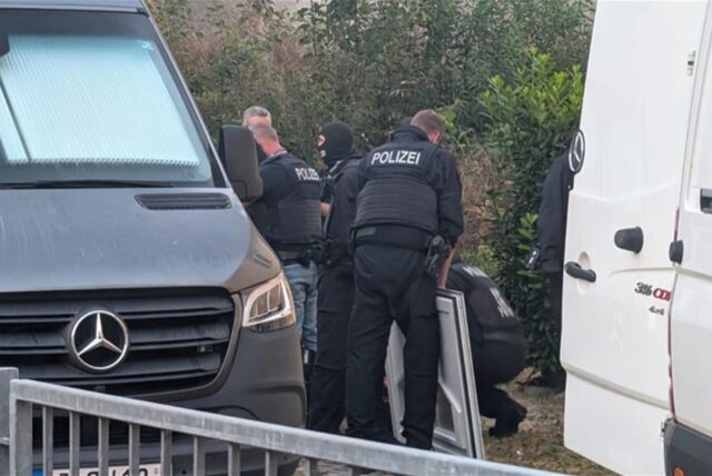 Polizeibeamte durchsuchen ein Gelände und Räume in Jena bei einer Schleuserrazzia.
