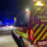 Ein Einsatzfahrzeug der Bergkamener Feuerwehr steht in der Nacht an einer Straßenabsperrung.