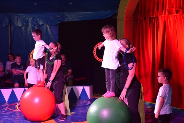 Kinder balancieren auf Gymnastikbällen.