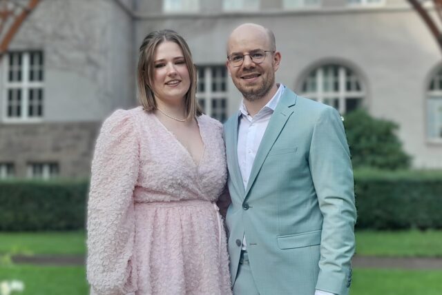 Janine und Max stehen frisch verheiratet vor dem Schwerter Rathaus.