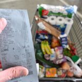 Ein Verbraucher hält nach einem Einkauf in einem Supermarkt einen Kassenzettel in der Hand.