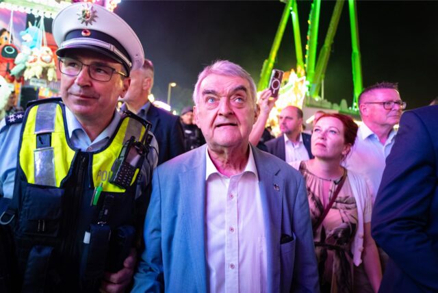 Herbert Reul (CDU), Innenminister von Nordrhein-Westfalen, besucht neben dem Polizisten Ronny Differding den Jahrmarkt „Pützchens Markt“ im Bonner Stadtteil Beuel, um sich über die Sicherheitsmaßnahmen zu Informieren.