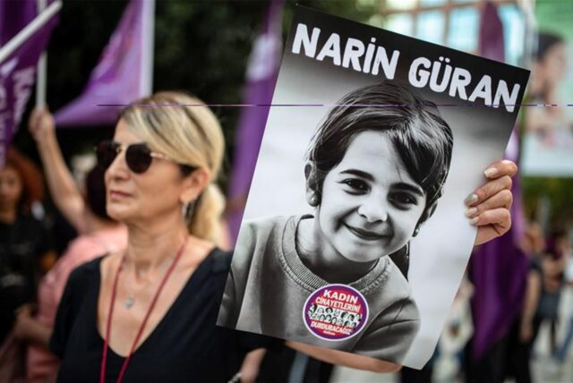 Eine Demonstrantin hält ein Porträt von Narin Guran hoch.