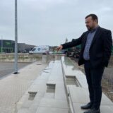 Bürgermeister Dimitrios Axourgos steht auf dem Gelände der neuen Sportarena in Schwerte-Wandhofen, er zeigt auf das Beach-Volleyballfeld.